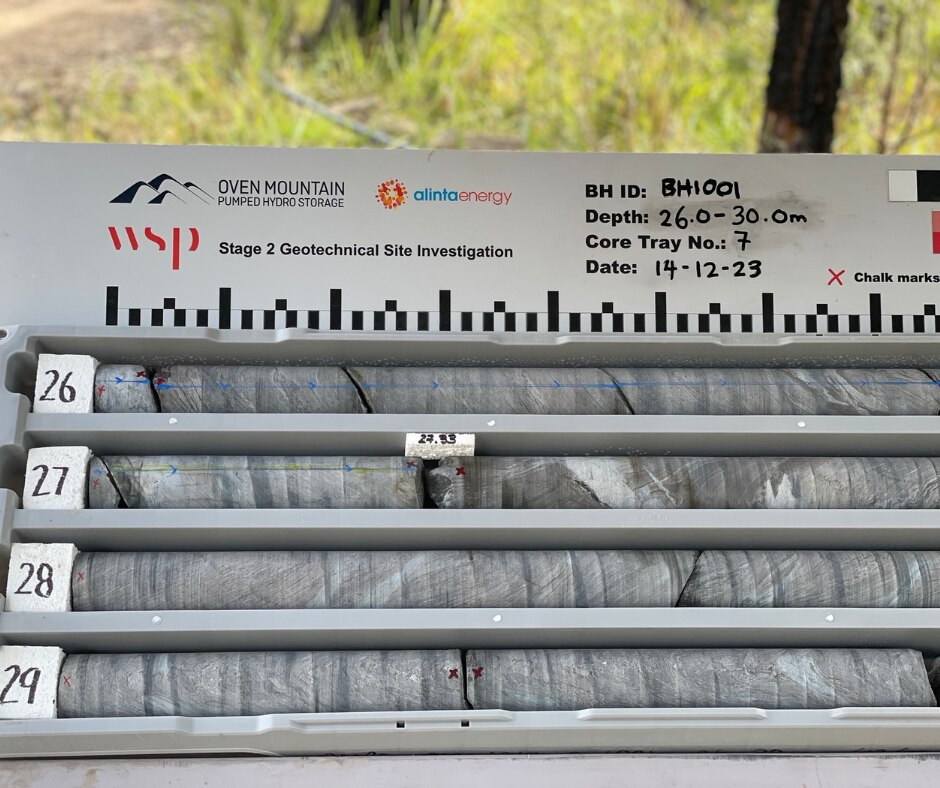 An image of four extracted sample rods lined up in a row numbered 26-29. They are grey in colour.